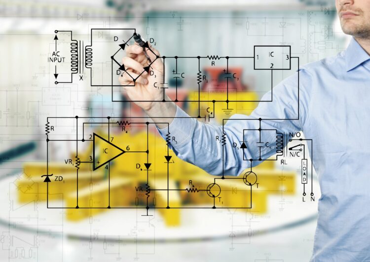 electrical engineer draws a diagram of a circuit. power plant interior in background