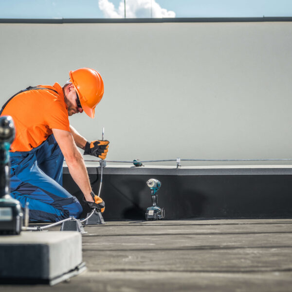 man installing Lightning Protection System on roof